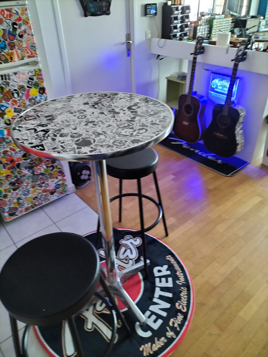 Coin d'accueil de l'atelier avec table et tabourets